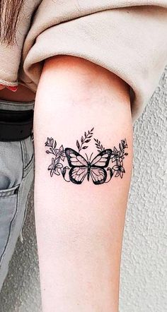 a woman's arm with a butterfly tattoo on the left side of her arm