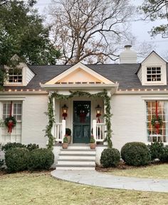 a white house decorated for christmas with wreaths and lights