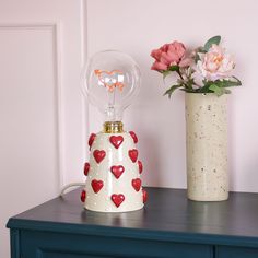 two vases with hearts are sitting on a table