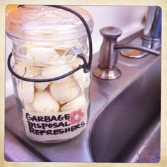 a glass jar filled with garbage sitting on top of a sink