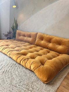 an orange futon couch sitting on top of a white rug