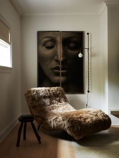 a living room with a chair and paintings on the wall