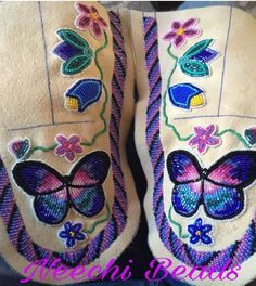 pair of slippers with butterfly appliqued on the front and back side