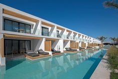 an outdoor swimming pool with lounge chairs next to it