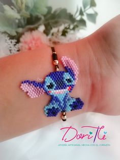 the bracelet is made up of beads and has an adorable little stitchy animal on it