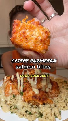 someone holding up a piece of food over rice on a plate with the caption, crispy parmesan salmon bites good luck just