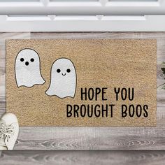 a door mat with two ghost faces and the words hope you brought boos on it