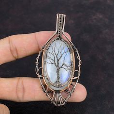 Note : Due to the natural formation of this gemstone. Slight variation in design and color are to be expected.  Tree Of Life Rainbow Moonstone Pendant Copper Wire Wrapped Gemstone Pendant Tree Of Life Jewelry Handmade Pendant Copper Jewelry For Gift Handmade Copper Pendant SKU : VFWP-932 Gemstone : Rainbow Moonstone Stone Shape : Oval    Metal Purity : Copper Pendant Length : 84 MM   Pendant Width : 40 MM A natural Moonstone opens the Heart Chakra in the human body that helps increase the psychic abilities. Moonstone the emotional healer: A Natural Moonstone encourages feelings of power and natural stability. It balances your emotions and makes the wearer feel confident in any situation. Wire Wrapped Gemstones Pendant, Tree Of Life Jewelry, Copper Wire Jewelry, Rainbow Moonstone Pendant, Moonstone Stone, Labradorite Jewelry, Moonstone Pendant, Handmade Copper, Copper Pendants