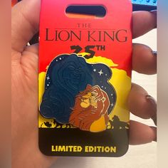 the lion king pin is being held up by someone's hand and it looks like they are going to die