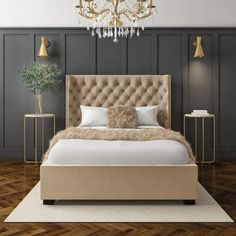 a large bed sitting on top of a wooden floor next to a chandelier