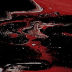 red and black liquid is seen in this artistic photograph, with white dots on the bottom