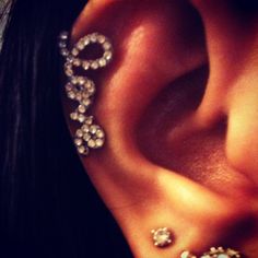 a close up of a person's ear with some piercings attached to it