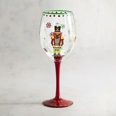 a red wine glass with a nutcracker painted on it