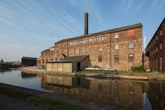 an old brick factory next to a body of water in front of a building with the word minecraft pottery written on it