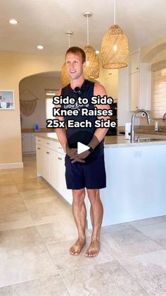 a man standing in the middle of a kitchen next to a sink and counter top