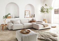 a living room filled with furniture and a large white couch in front of a window