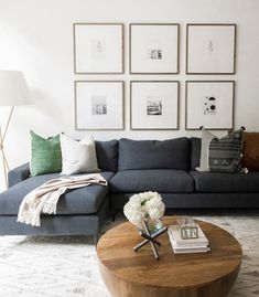 a living room filled with furniture and pictures on the wall above it's coffee table