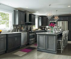 a large kitchen with wooden floors and gray cabinets, along with a dining room table