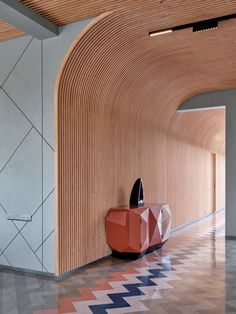 an orange table sitting in the middle of a room next to a wall with geometric designs on it