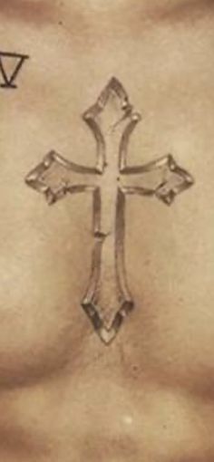 a cross tattoo on the side of a woman's stomach