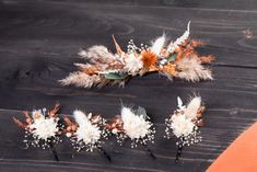 flowers and feathers are arranged on a wooden surface