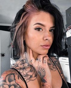 a woman with tattoos on her chest posing for the camera