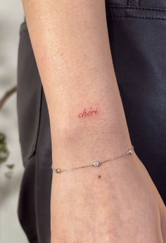 a woman wearing a bracelet with the word aori on it's left wrist