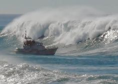 a large boat in the water with a huge wave behind it