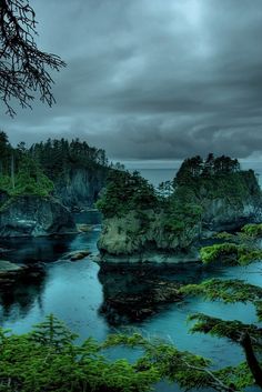 the water is very blue and green with rocks on both sides, surrounded by trees