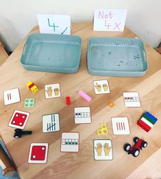 two plastic trays filled with different types of toys on top of a wooden table