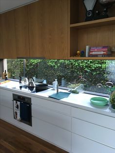 a kitchen with wooden cabinets and white counter tops is seen through the window sill