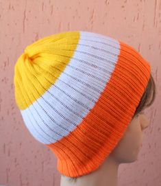 a mannequin head wearing an orange, white and yellow striped knitted hat