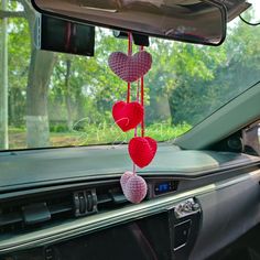 two hearts hanging from the dashboard of a car