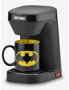 the batman coffee maker is on display with its cup in it's holder and lid