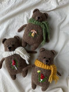 three knitted teddy bears laying on top of a bed