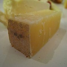 a close up of a piece of cake on a white and blue plate with wood table in the background