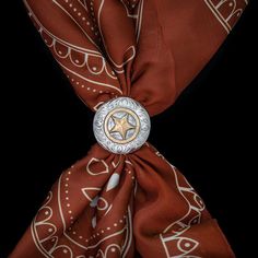 A standout Western classic. This hand-engraved scarf slide is constructed of solid sterling silver, accented with a 14k gold fill three-dimensional star and serpentine engraved disc. Wear your wild rag with style. Measures 1 1/2" by 1 1/2" All Vogt sterling items come with the Vogt Family Unconditional Lifetime Guarantee. If for any reason your Vogt piece bends, breaks, or cracks it will be repaired or replaced free of charge. No questions asked. Men’s Western Jewelry, Western Scarf Tie, Southwestern Silver Bolo Ties For Rodeo, Adjustable Southwestern Bolo Tie, Southwestern Style Sterling Silver Bolo Tie, Cowboy Cross, Scarf Slide, Lucky Horseshoe, Wild Rag