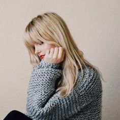 a woman sitting down with her hand on her face