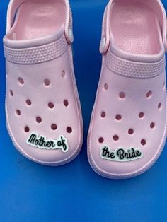 a pair of pink crocs with the words mother of the bride written on them