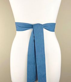 a white mannequin with a blue tie around it's waist and torso