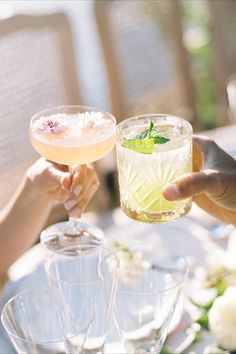 three glasses filled with different types of drinks sitting on a table next to each other