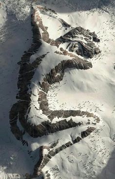 an aerial view of snow covered mountains and valleys