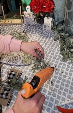 a woman is using scissors to cut flowers