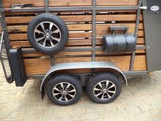 the trailer is made out of wood and has wheels on each side, as well as two large tires