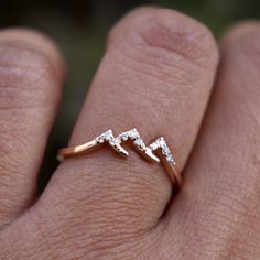 a woman's hand with a diamond ring on her left hand and two diamonds in the middle