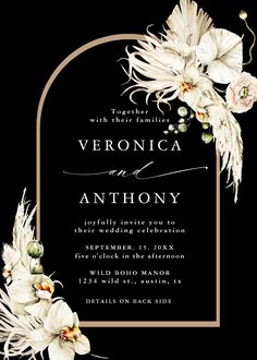 an elegant wedding card with white flowers and greenery in the center, on black background