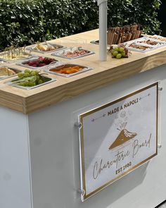 an outdoor food stand with many different types of foods on it's display trays