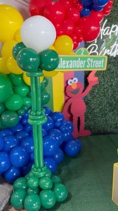 balloons are arranged in the shape of flowers and trees at a birthday party with sesame street characters