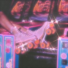 a pair of roller skates sitting on top of some colorful speakers in front of a neon sign