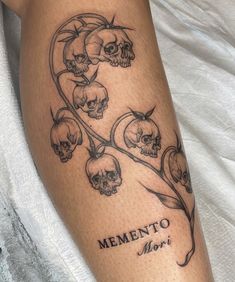 a woman's leg with skulls and flowers on it